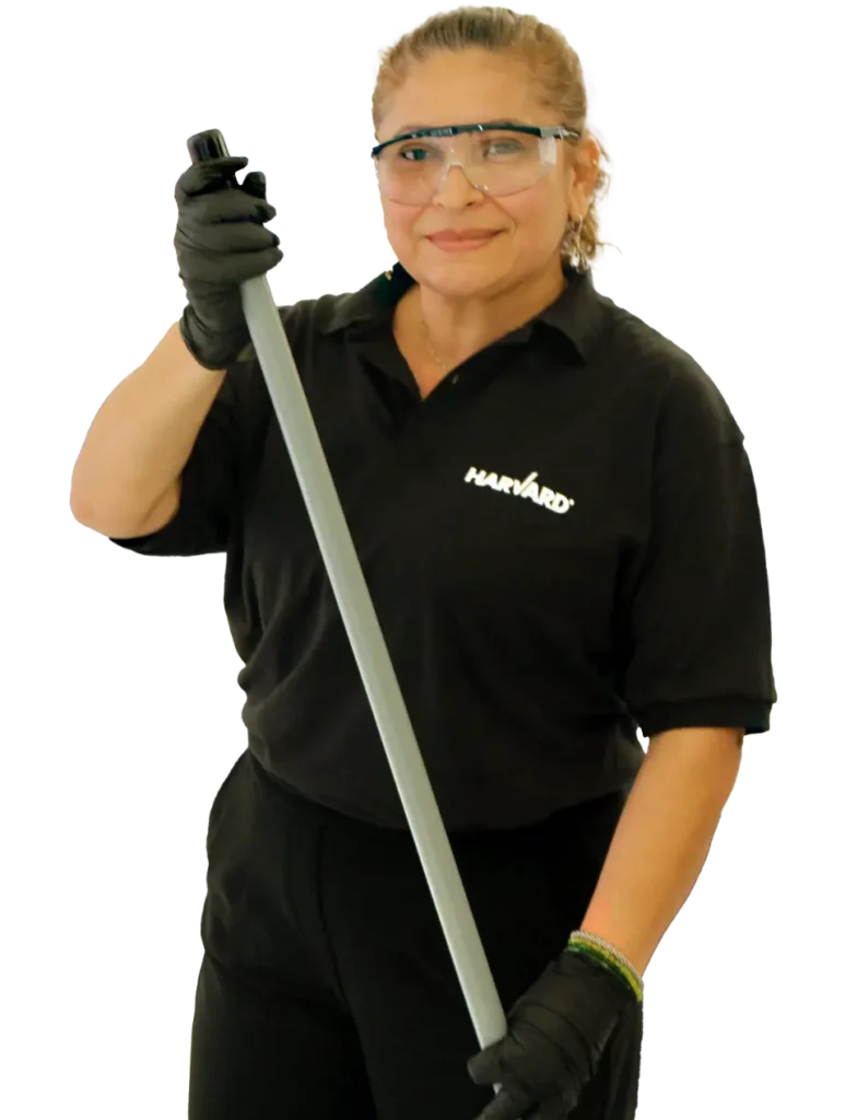 harvard-maintenance-janitorial-services A woman in a black uniform and safety glasses holding a mop handle.